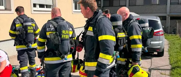 Feuerwehrleute vor einem Wohnhaus
