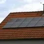 Großaufnahme eines Hausdachs mit Kamin, mit einer PV-Anlage