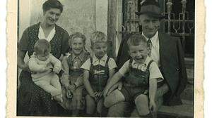Der Schriftsteller Josef Winkler, Mitte der 1950er Jahre im Kreis der Familie vor dem Haus in Kamering - er sitzt auf dem Schoß der Mutter