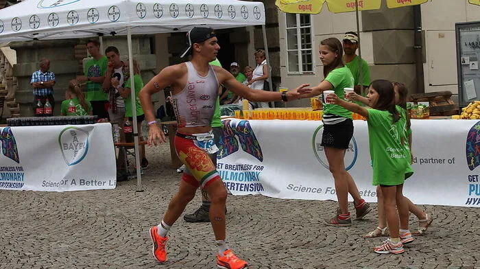 An den Labestationen herrscht beim Ironman reges Treiben. Selbst ganz junge Freiwillige sind gerne mittendrin. Der Dienst an der Laufstrecke dauert bis Mitternacht