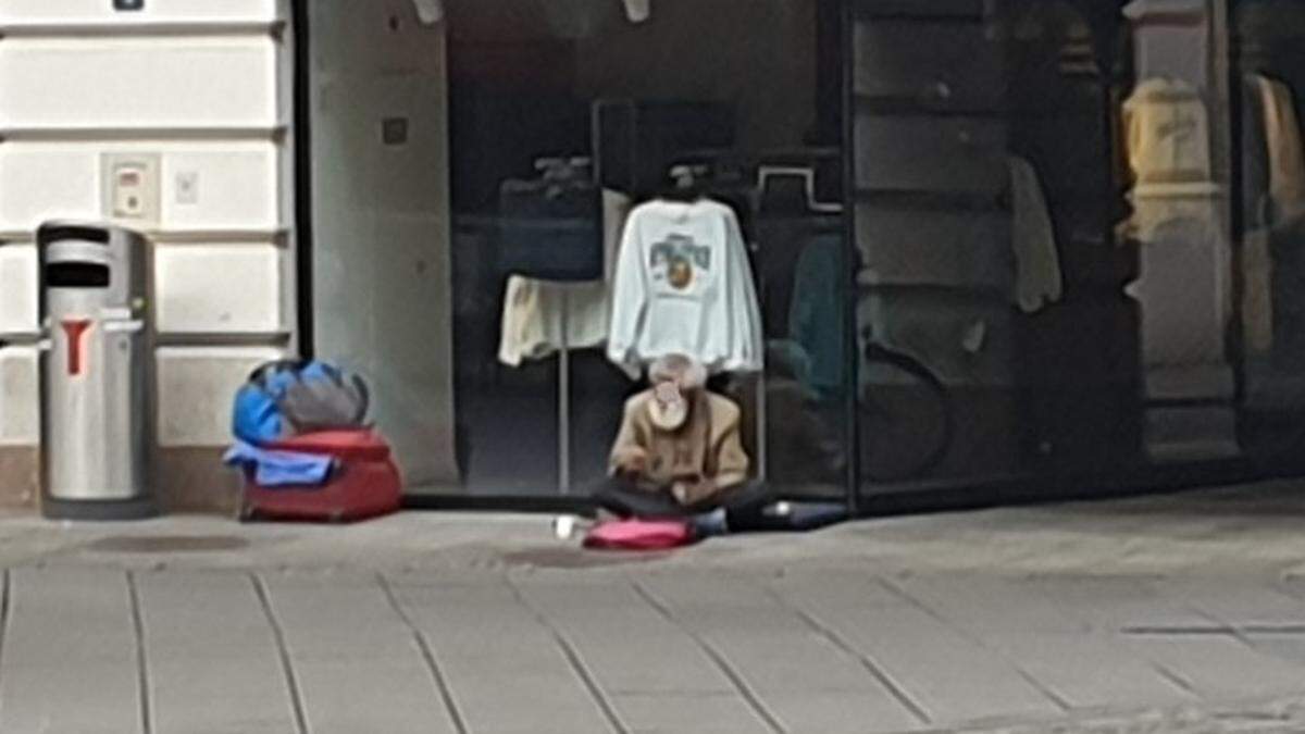 Der obdachlose Mann sitzt neben seinen akkurat gestapelten Habseligkeiten – kurz danach ist der Platz geräumt