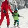 Skiing instructor working with little boy