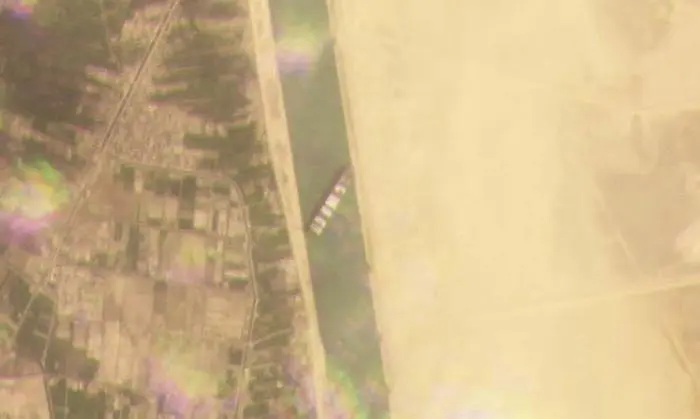 This satellite image from Planet Labs Inc. shows the cargo ship MV Ever Given stuck in the Suez Canal near Suez, Egypt, Tuesday, March 23, 2021. A cargo container ship that's among the largest in the world has turned sideways and blocked all traffic in Egypt's Suez Canal, officials said Wednesday, March 24, 2021, threatening to disrupt a global shipping system already strained by the coronavirus pandemic. (Planet Labs Inc. via AP)