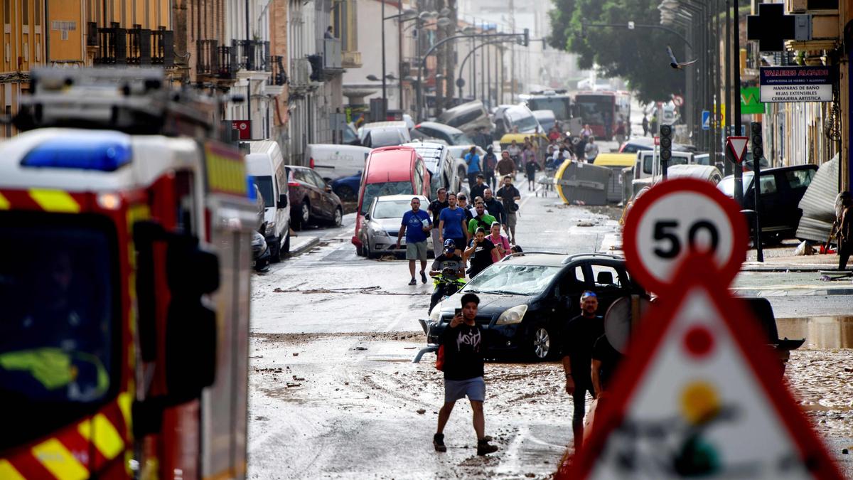 Anwohner neben den Autos, die von den Überschwemmungen in Valencia weggeschwemmt wurden