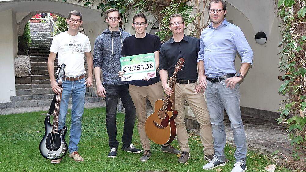 Fünf der sechs Musiker präsentieren den Scheck für „Steirer helfen Steirern“