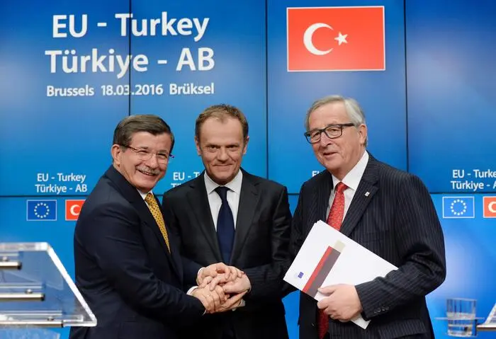 Der türkische Ministerpräsident Ahmet Davutoğlu, der Präsident des Europäischen Rates Donald Tusk (Mitte) und der Präsident der Europäischen Kommission Jean-Claude Juncker (rechts) posieren nach dem EU-Gipfel im Gebäude des Europäischen Rates in Brüssel am 18. März 2016 für ein Foto.