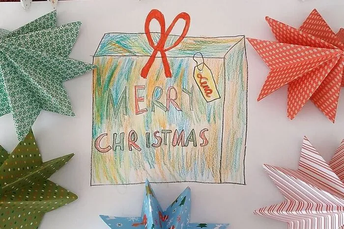 Lena Passath (9) aus St. Lorenzen hat für unsere Leser zahlreiche Christbäume gefaltet, unter denen die Zeichnung eines hübsch eingepackten Weihnachtsgeschenks liegt.