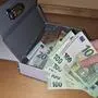Jemand stiehlt Geld aus einer Handkassa
