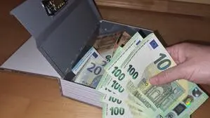 Jemand stiehlt Geld aus einer Handkassa