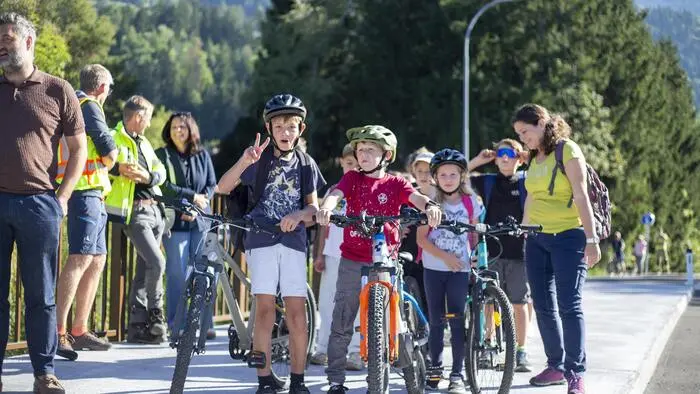 Kinder mit ihren Fahrrädern stehen auf dem verbreiterten Rad- und Fußweg der Debantbachbrücke