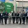 Neun Männer stehen vor einem grünen Lkw mit der Aufschrift „Kelag“ und durchschneiden symbolisch ein grünes Band