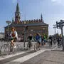 Eine Gruppe von Radfahrerinnen und Radfahrern fährt durch die Innenstadt von Kopenhagen.  | 56 Prozent der Bevölkerung Kopenhagens fahren täglich mit dem Fahrrad