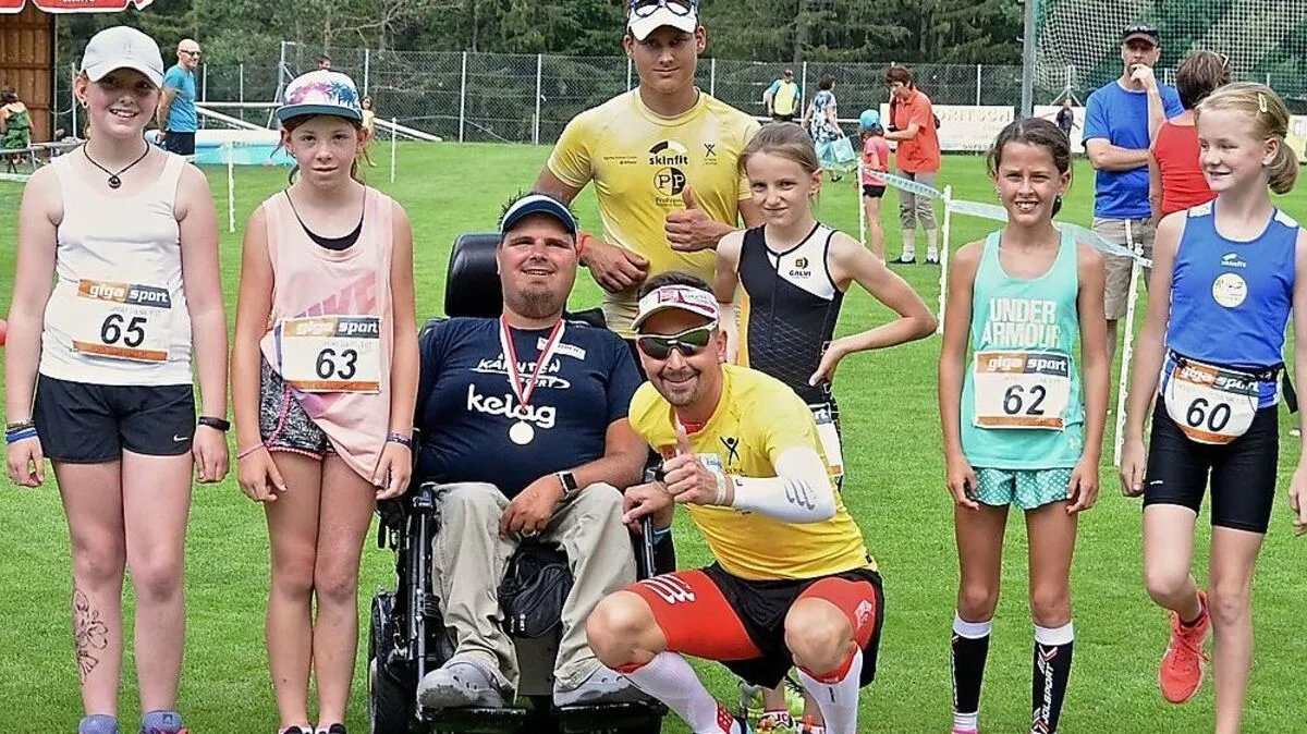 Dominik Pacher vom SV Penk (mit Brille)  mit einem Teilnehmer der Lebenshilfe sowie junge Sportlerinnen und Sportler auf dem Fußballplatz in Napplach