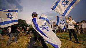 Jüdische Kinder schwenken in der Siedlung Mehola im Jordantal israelische Flaggen