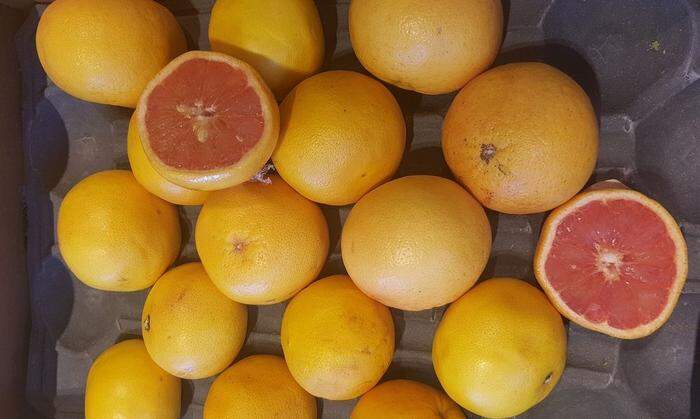 Halbierte Grapefruits im Supermarkt, feinsäuberlich in Plastikfolie gewickelt