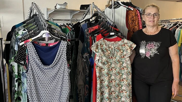 Glantschnig steht vor mehreren Second-Hand-Kleidern