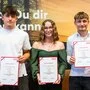 Drei junge Personen halten Urkunden