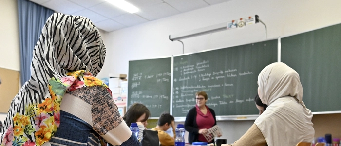 Blick in ein Klassenzimmer, in dem zwei Mädchen mit Kopftüchern zu sehen sind