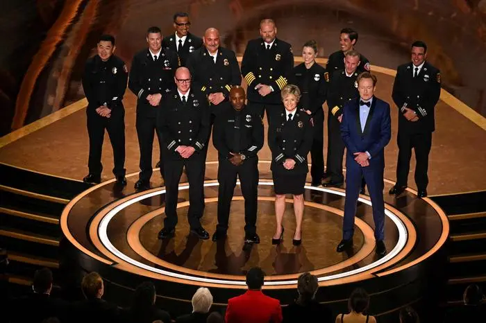 (From L) Los Angeles Fire Department (LAFD) Captain Erik Scott, LAFD helicopter pilot Jonith Johnson Jr. and Pasadena Fire Captain Jodi Slicker speak onstage next to US comedian and host Conan O'Brien during the 97th Annual Academy Awards at the Dolby Theatre in Hollywood, California on March 2, 2025. (Photo by Patrick T. Fallon / AFP)