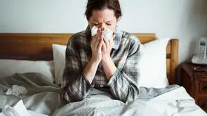 A woman suffering from flu in bed
