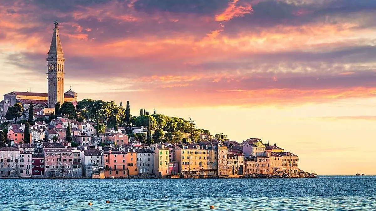 Great spring sunset of Rovinj town, Croatian fishing port on the west coast of the Istrian peninsula. Colorful evening seascape of Adriatic Sea. Traveling concept background.