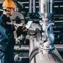 Portrait of young Caucasian man dressed in work wear using tablet while standing in heating plant.
