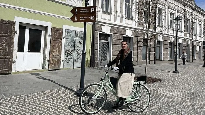 Stilecht im 30er-Jahre-Outfit auf einem Retro-Puch-Rad führt Guide Tina durch die alte Lederhochburg