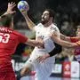 France's Nikola Karabatic, center, Austria's Mykola Bilyk, left, and Austria's Lukas Hutecek, right, challenge during the Handball European Championship main round match between France and Austria in Cologne, Germany, Monday, Jan. 22, 2024. (AP Photo/Martin Meissner)