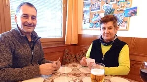 Mann und Frau sitzen am Wirtshaustisch und spielen Karten