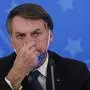 Brazil's President Jair Bolsonaro gestures during a press conference on the coronavirus pandemic COVID-19 at the Planalto Palace in Brasilia, Brazil on March 20, 2020. - Brazil's government on Friday drastically downgraded its growth projections for 2020 by 2.1 percent to practically zero (0.02 percent) due to the coronavirus pandemic. (Photo by Sergio LIMA / AFP)