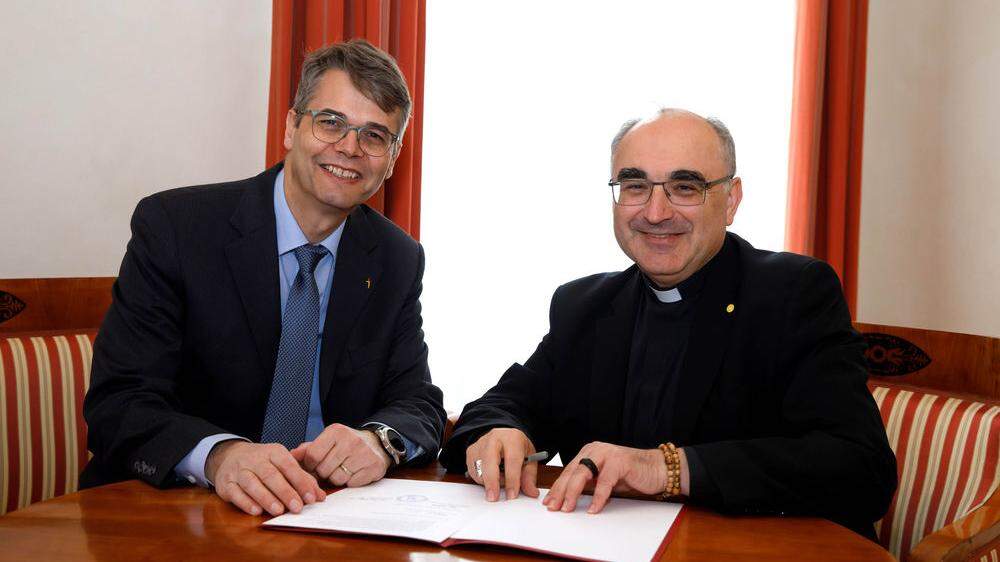 Superintendent Wolfgang Rehner und Bischof Wilhelm Krautwaschl beim Unterzeichnen der neuen Vereinbarung