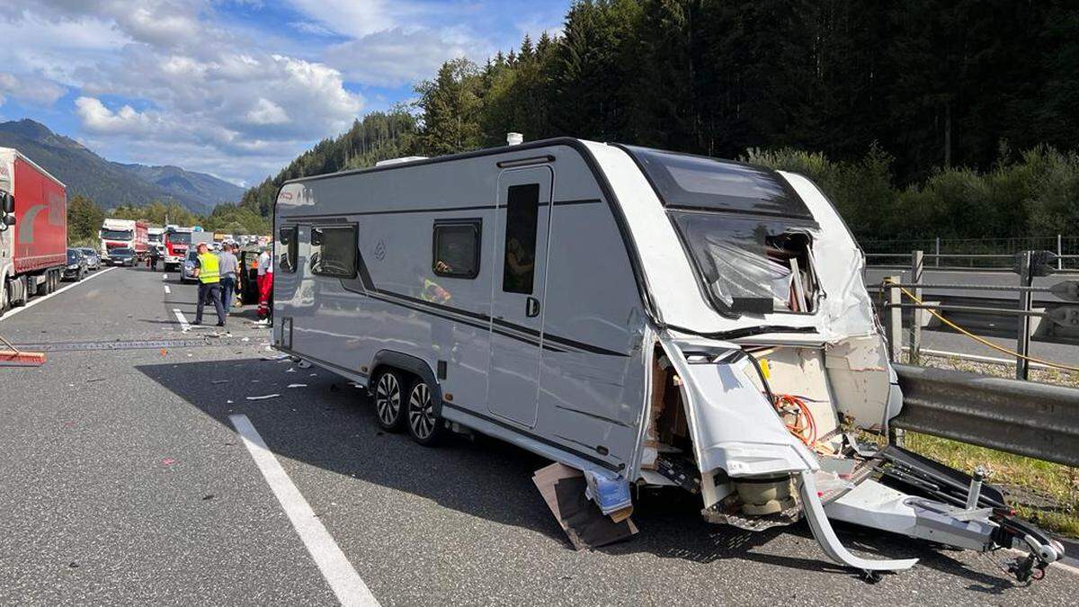 Die Einsatzkräfte bei dem verunfallten Wohnwagen