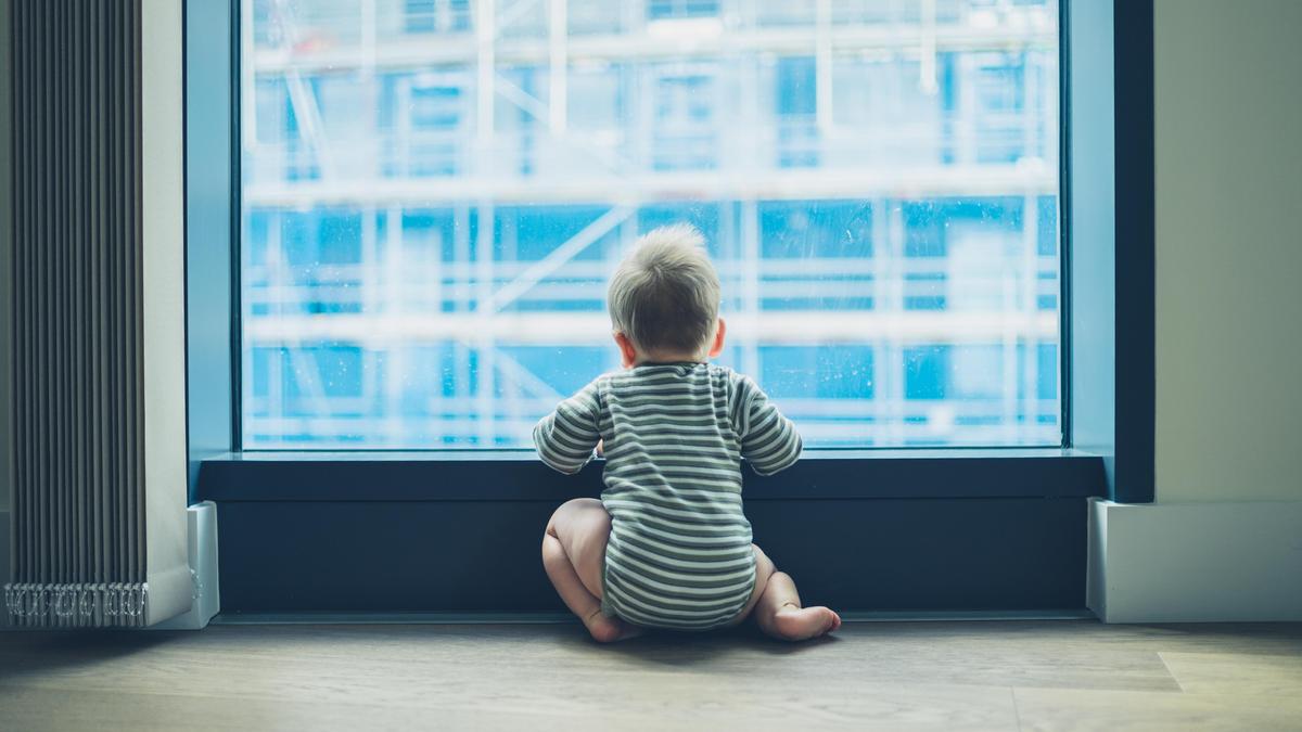 Ein Kleinkind unbeaufsichtigt vor einem Fenster - eine potentiell tödliche Gefahr (Symbolbild)