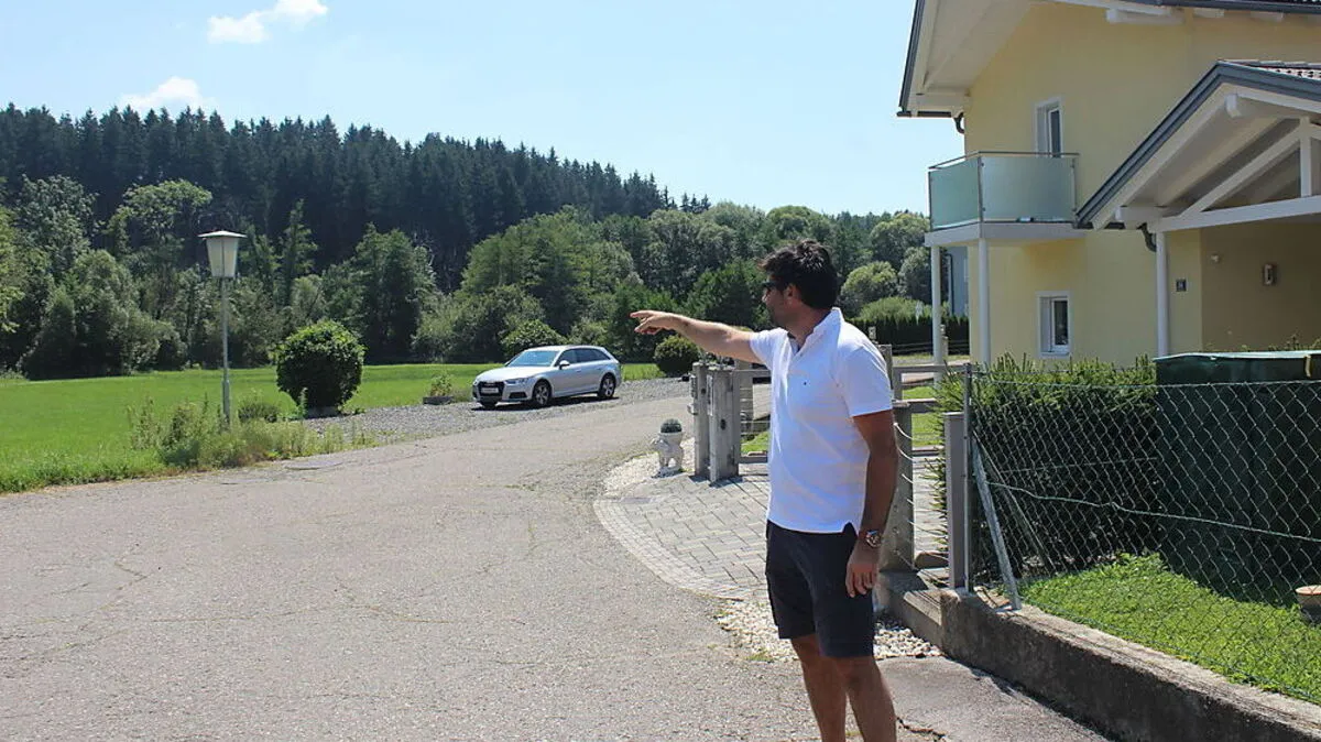 Wilfried Krappinger zeigt auf die Stelle: Von der Straße bei den Häusern wurde auf das Reh geschossen