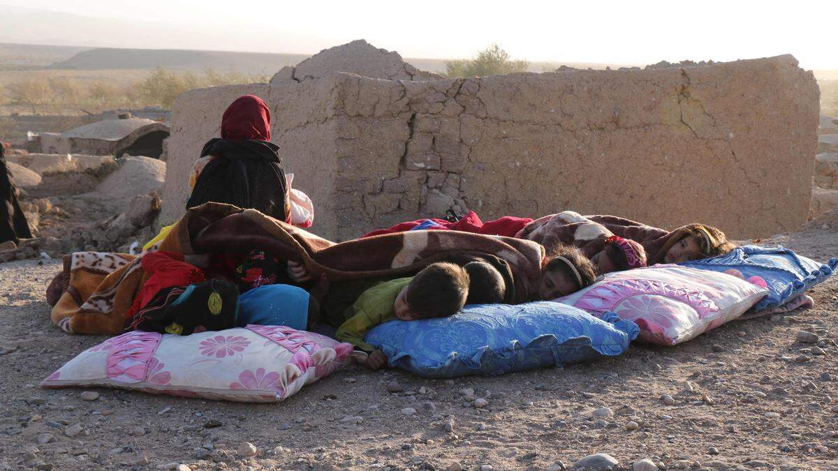 Kinder vor einem eingestürzten Haus in Zendeh Jan in der Provinz Herat