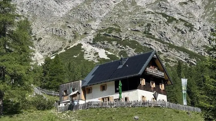 Das ÖTK-Schutzhaus auf der Kerschbaumeralm vor einer Felswand