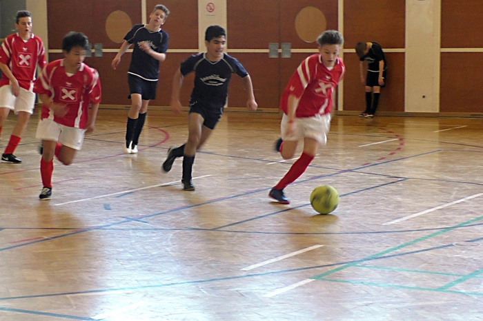 Das Siegerteam in den rot-weißen Dressen - die NMS Sinabelkirchen (2. von links, Torschützenkönig Raul Yabounaka, Spieler am Ball: Marco Wagner - Teamkapitän)