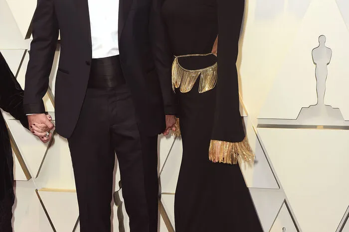 Bradley Cooper hatte sich für einen Anzug des Designers Tom Ford entschieden, seine Verlobte Irina Shayk erschien in einem langärmeligen Burberry-Kleid mit Goldapplikationen.