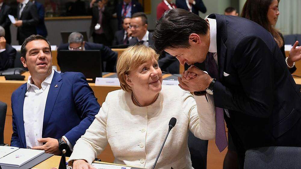 Die EU zerpflückt Italiens Haushaltsplan, derweilen küsst Italiens Premier Giuseppe Conte Angela Merkels Hand. Amüsiert: Griechenlands Premier Alexis Tsipras 