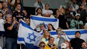 Israel's supporters wave flags before the start of the men's group D football match between Israel and Paraguay during the Paris 2024 Olympic Games at the Parc des Princes in Paris on July 27, 2024. (Photo by GEOFFROY VAN DER HASSELT / AFP)