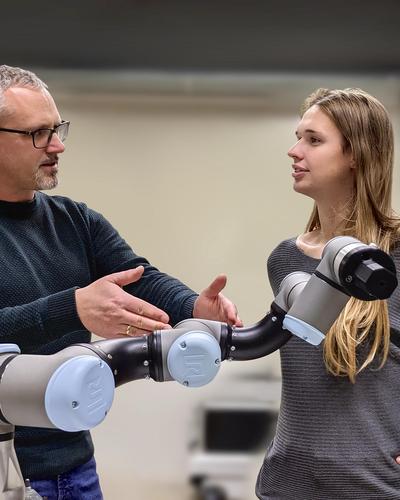 
Mathias Brandstötter (links) arbeitet mit Studierenden wie Kayleigh van Niehoff an der Optimierung des Roboterarms	FH