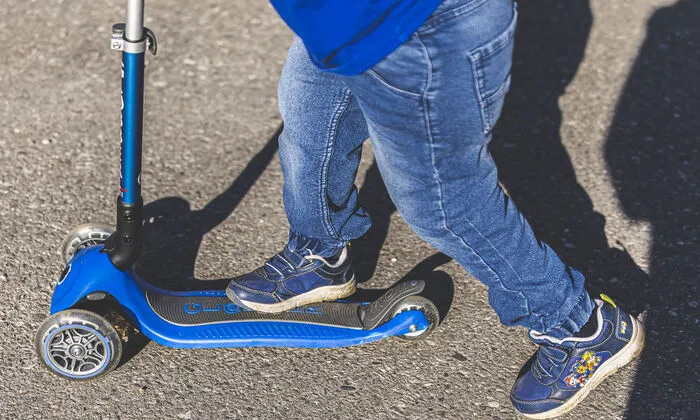 Mit den Kinderprothesen fährt Nico auf dem Roller. Seine Mutter muss schauen, dass sie ihm nachkommt