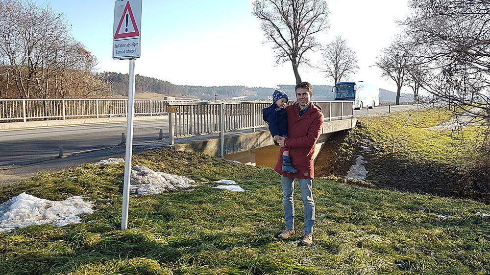 David Venus mit Sohn Theo vor der Straßenbrücke über den Marbach.