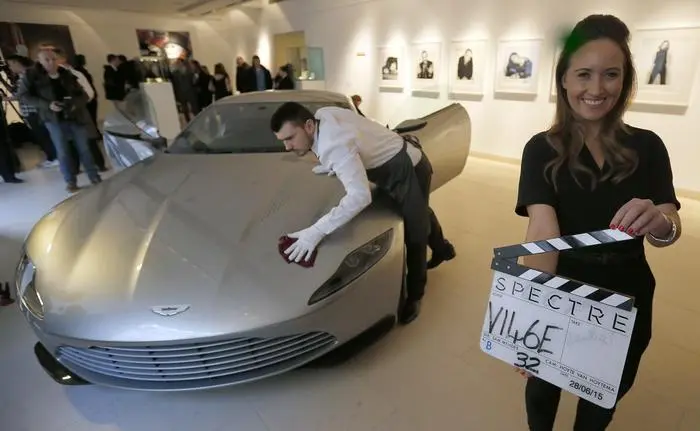 A Christie's employee poses, right, as another polishes the James Bond Aston Martin of the latest Spectre movie at the auction house Christie's in London, Monday, Feb. 15, 2016. The live auction on Feb.18, is led by an Aston Martin DB10, one of the series of DB10s designed and engineered by Aston Martin exclusively for James Bond, Spectre. The car is expected to realise between £1,000,000 and £1,500,000 (1,45 million-2,17 million USD) and is to date the only DB10 to be released for public sale by EON Productions and Aston Martin. (AP Photo/Frank Augstein)