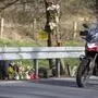 Ein Motorradfahrer fährt an einem Unfallort vorbei, an dem Kerzen liegen