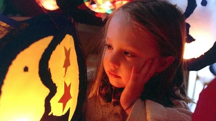 Kinder ziehen mit selbst gebastelten Laternen durch die Straßen und singen Martinslieder