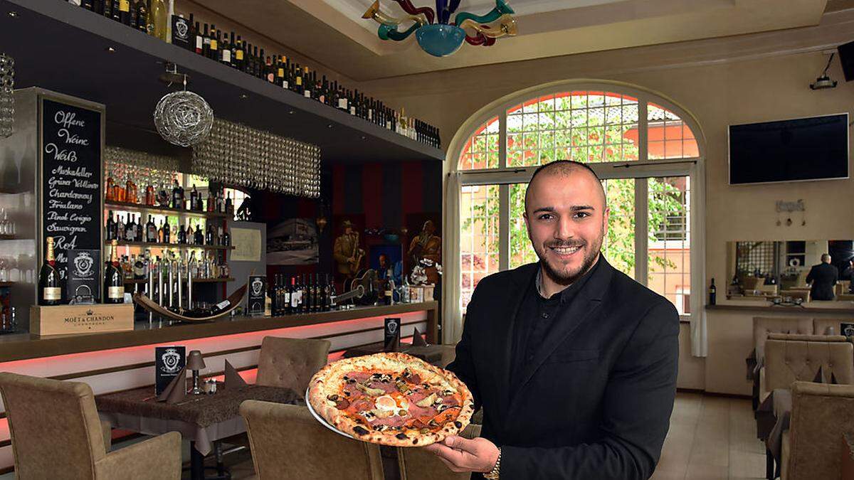 Denijol Esati mit der „Lapidarium“-Pizza aus dem Steinofen