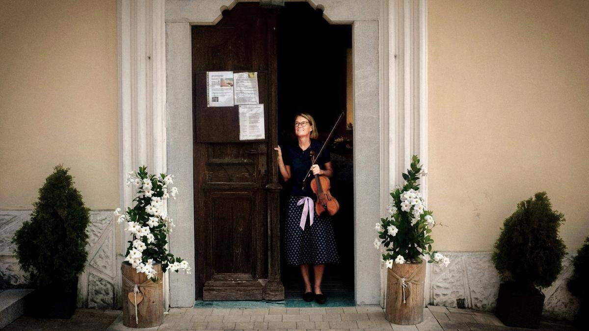 Veronika Ambrosch mit ihrer Geige vor der Kirche von Treßdorf: „Seelsorge geht nur, wenn man sich begegnet.“