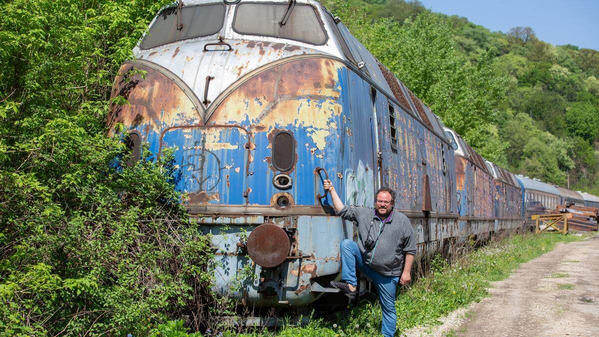 Christoph Posch vor einer der blauen Loks, die vor der Remise in Belgrad rosten