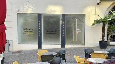 Blick von außen auf eine verklebte Auslage eines Innenstadtgeschäfts